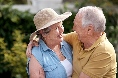 Buy stock photo Shot of an elderly couple embracing each other in their backyard