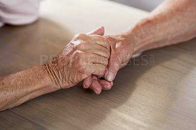 Buy stock photo Cropped shot of an unrecognizable couple holding hands at home