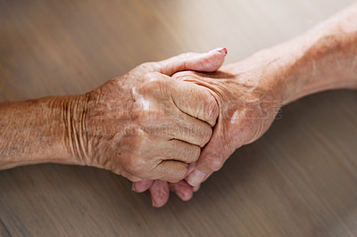 Buy stock photo Cropped shot of an unrecognizable couple holding hands at home