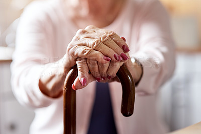 Buy stock photo Closeup shot of an unrecognizable elderly woman holding onto a cane at home