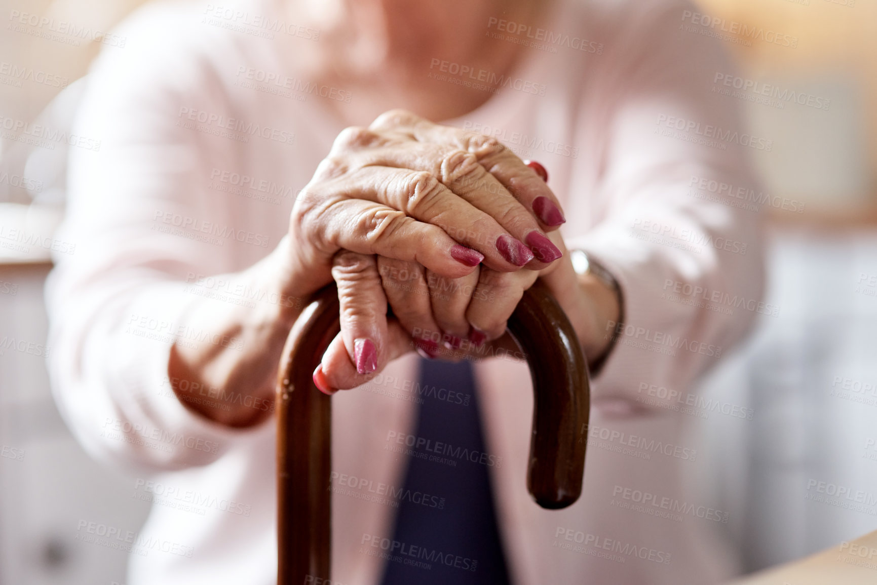 Buy stock photo Closeup shot of an unrecognizable elderly woman holding onto a cane at home