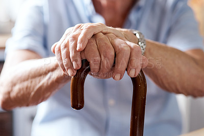Buy stock photo Closeup shot of an unrecognizable elderly man holding onto a cane at home