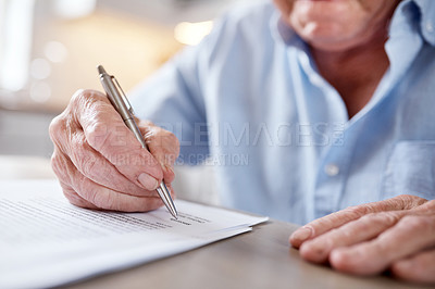 Buy stock photo Cropped shot of an unrecognizable man filling in forms at the kitchen table at home