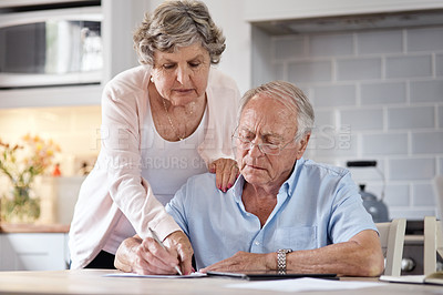 Buy stock photo Shot of an elderly couple going over paperwork at home