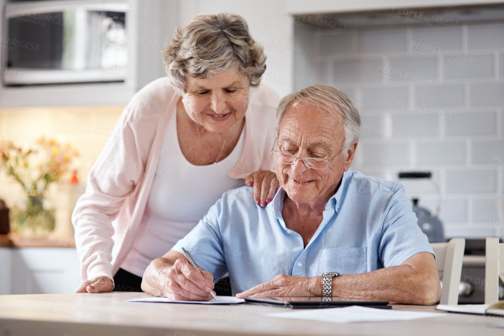 Buy stock photo Shot of an elderly couple going over paperwork at home