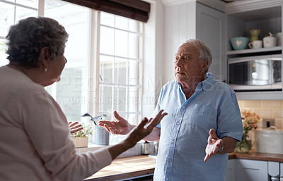 Buy stock photo Shot of an elderly couple have a heated dispute in the kitchen at home