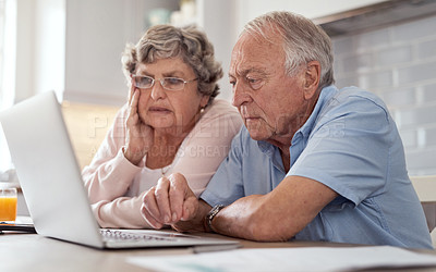 Buy stock photo Shot of an elderly couple using a laptop together in the kitchen at home