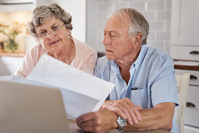 Buy stock photo Shot of an elderly couple going over paperwork together at the table at home