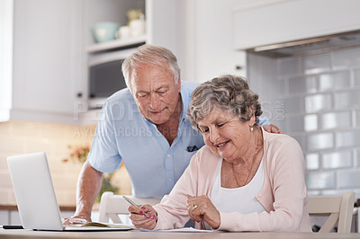 Buy stock photo Shot of an elderly couple going over paperwork at home