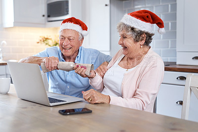 Buy stock photo Shot of an elderly couple holding a festive prop at the table at home