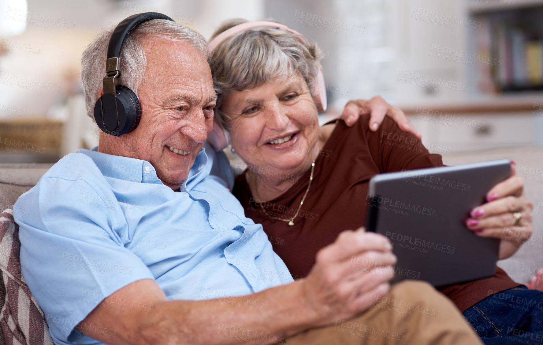 Buy stock photo Shot of an elderly couple using a digital tablet on the sofa at home