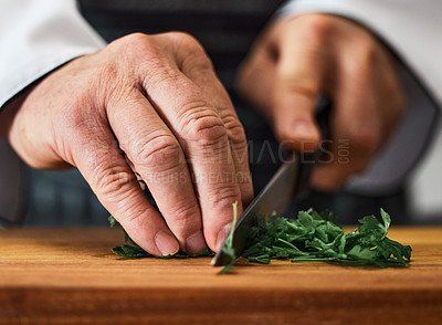 Buy stock photo Shot of an unrecognisable man slicing fresh parsley on a chopping board