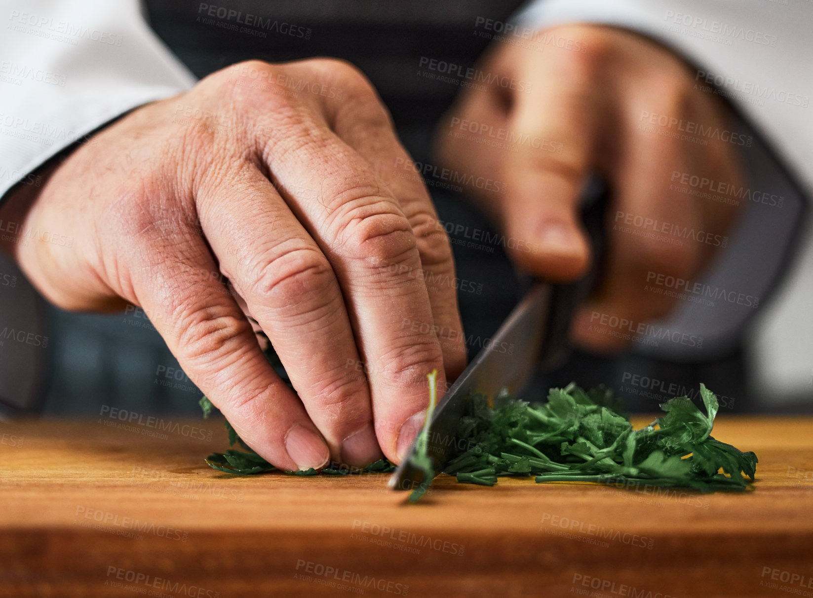 Buy stock photo Shot of an unrecognisable man slicing fresh parsley on a chopping board