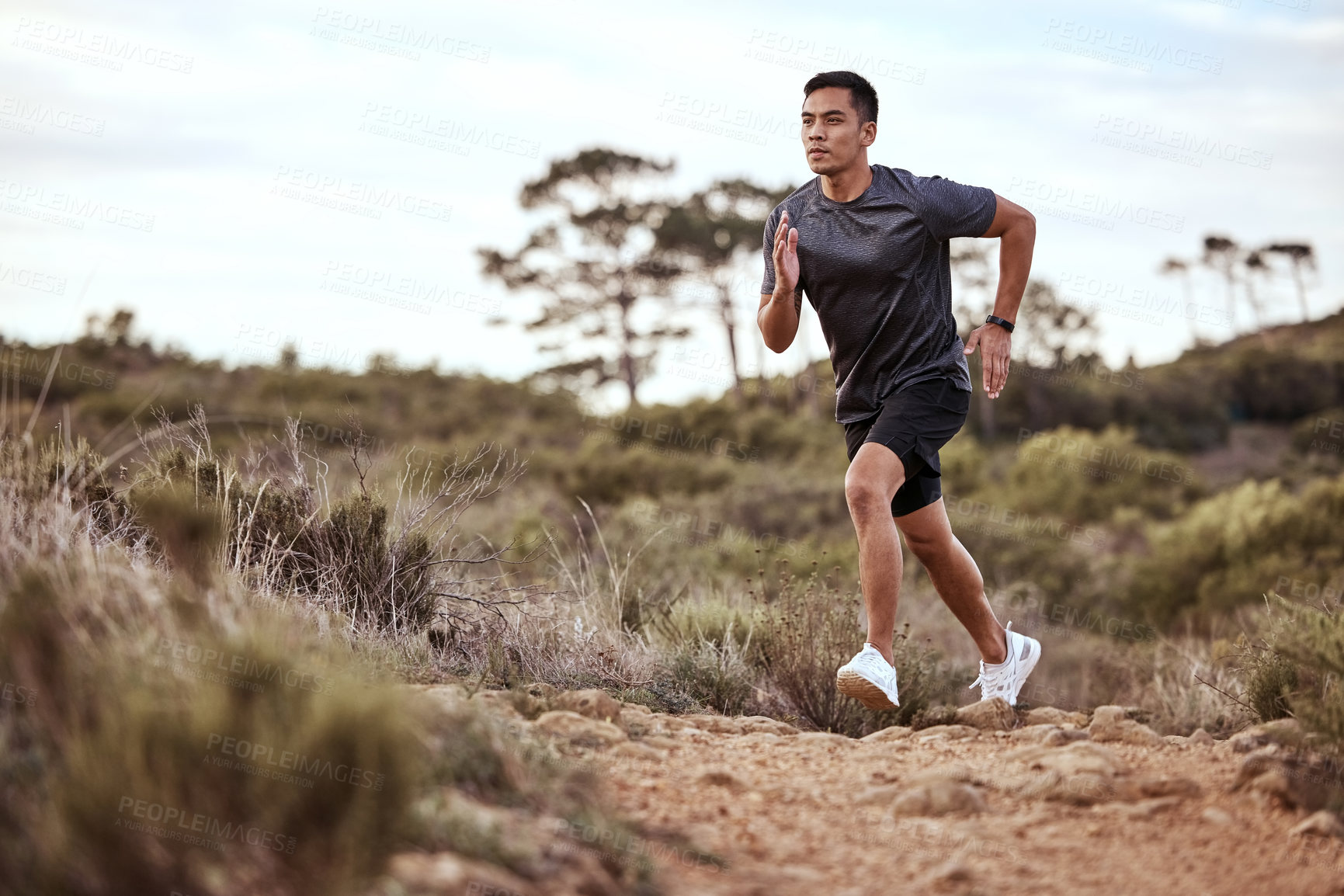 Buy stock photo Shot of a young man exercising in nature