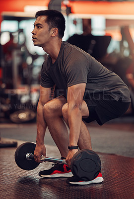 Buy stock photo Shot of a young man about to lift weights at the gym