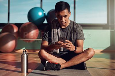Buy stock photo Gym, phone and man on floor with mobile app for fitness schedule, reading email or checking social media. Internet search, cellphone and workout, healthy male athlete on mat in pilates or yoga studio