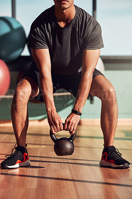 Buy stock photo Shot of a man working out in the gym using kettlebells