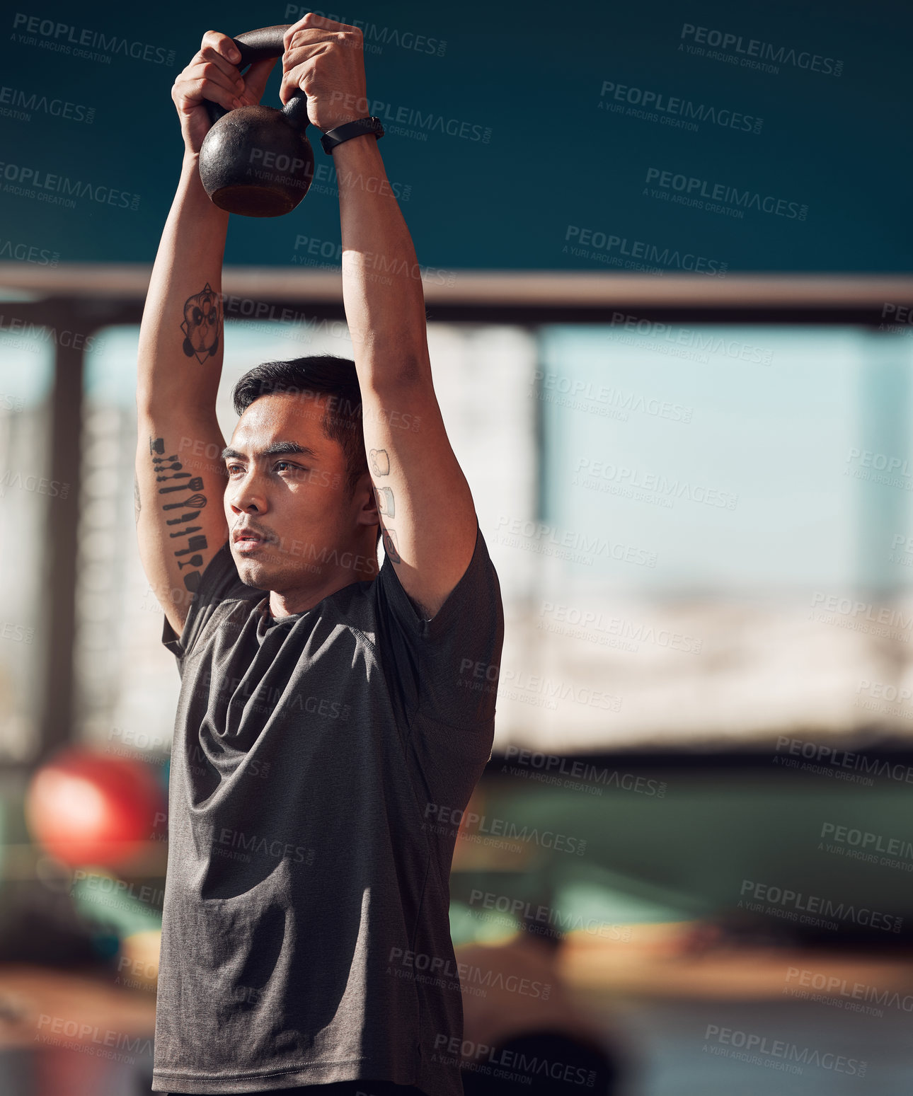 Buy stock photo Shot of a young man working out using a kettlebell in the gym