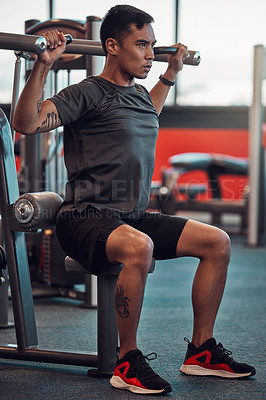 Buy stock photo Shot of a young man working out in the gym