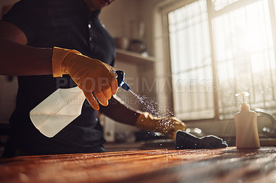 Buy stock photo Shot of an unrecognisable man disinfecting a kitchen counter at home