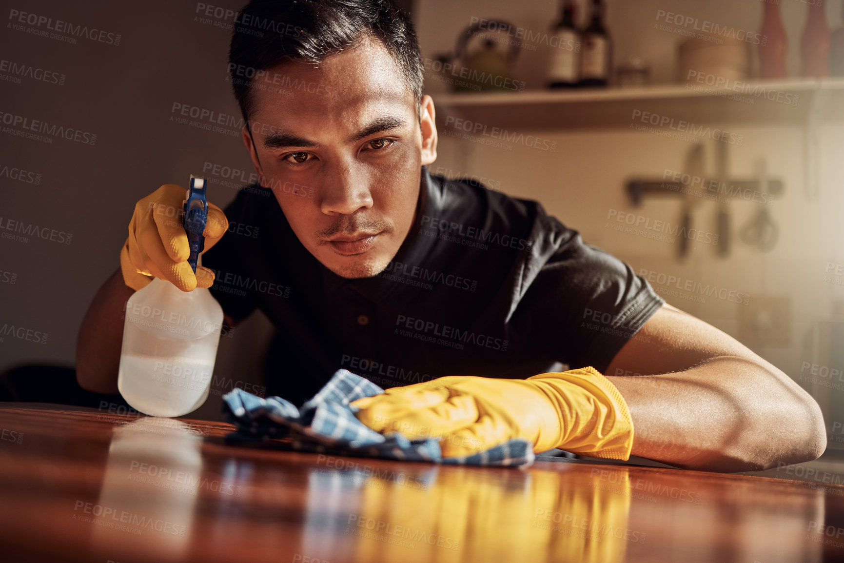 Buy stock photo Apartment, cleaning and man with disinfectant for kitchen counter, housekeeping and bacteria. Person, home and guy with spray bottle, cloth and routine with germaphobe, remove dust and chore with ocd