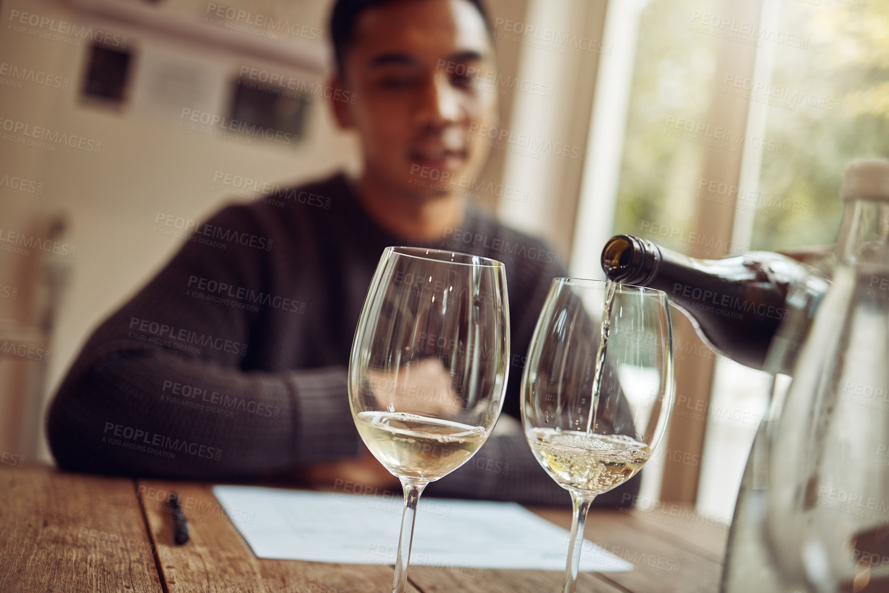 Buy stock photo Wine glasses, alcohol and man at vineyard restaurant for tasting, celebration or party for dining. Winery, bottle and male person with luxury alcohol champagne by table for dinner, banquet or event.