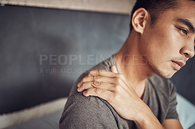 Buy stock photo Stress, sick and man with shoulder pain in his bedroom in recovery from an accident or injury. Illness, medical emergency and male person holding a sprain back muscle while resting in his apartment.