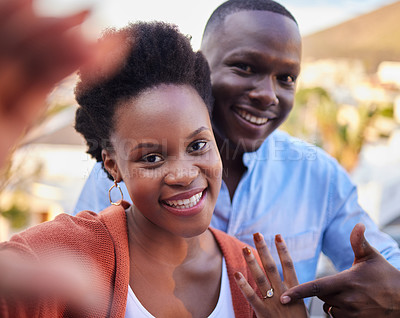 Buy stock photo African couple, selfie and happy with engagement ring in portrait with pointing for post on social network. Black woman, man and smile with jewelry for marriage proposal in profile picture on web