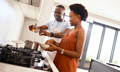 Buy stock photo Shot of a young couple in the kitchen making food  at home