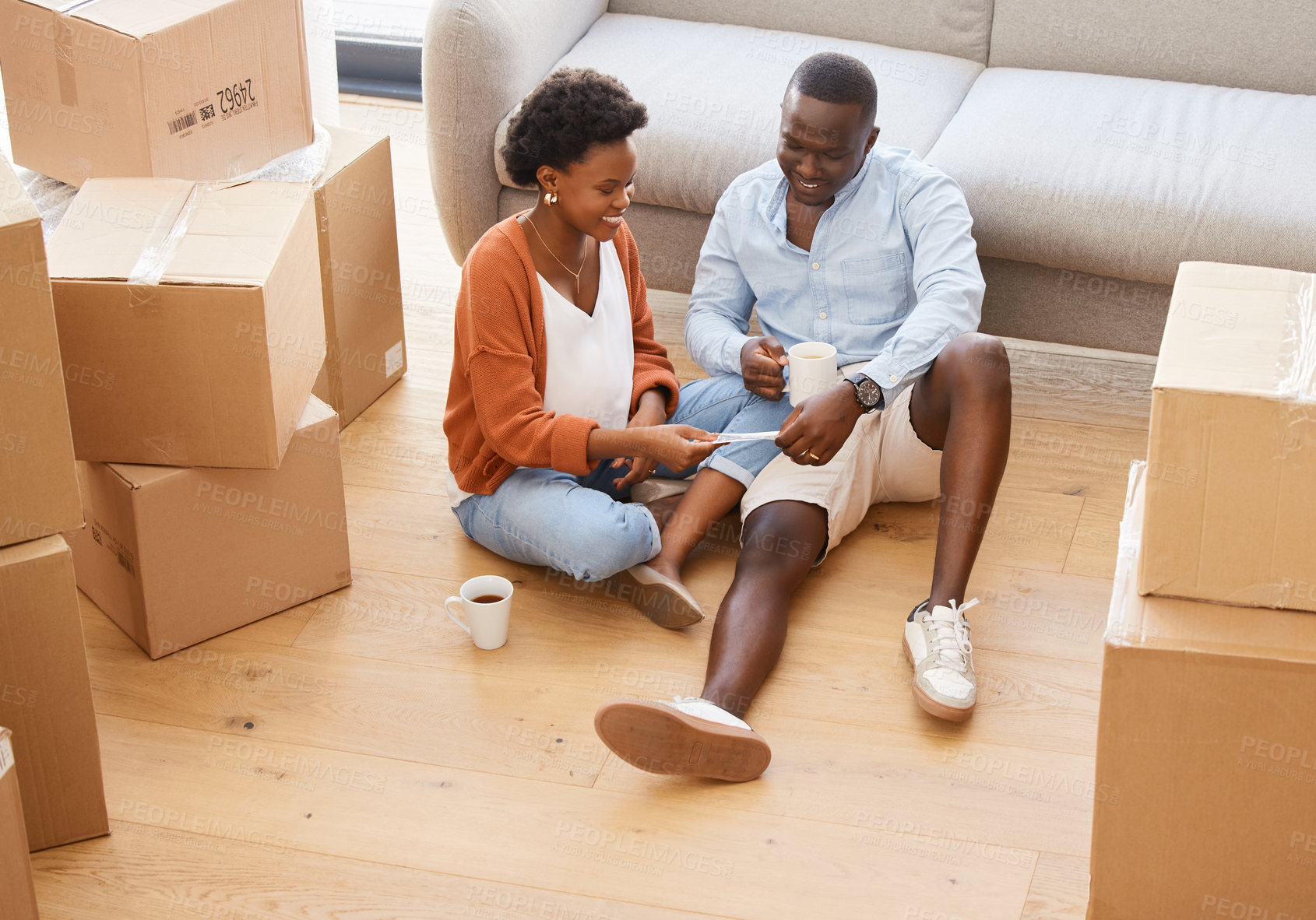 Buy stock photo Woman, man and boxes in pregnancy as happy for moving, house and relocating on floor in living room. African, couple and tea as excited in packing for apartment, new home and family with property
