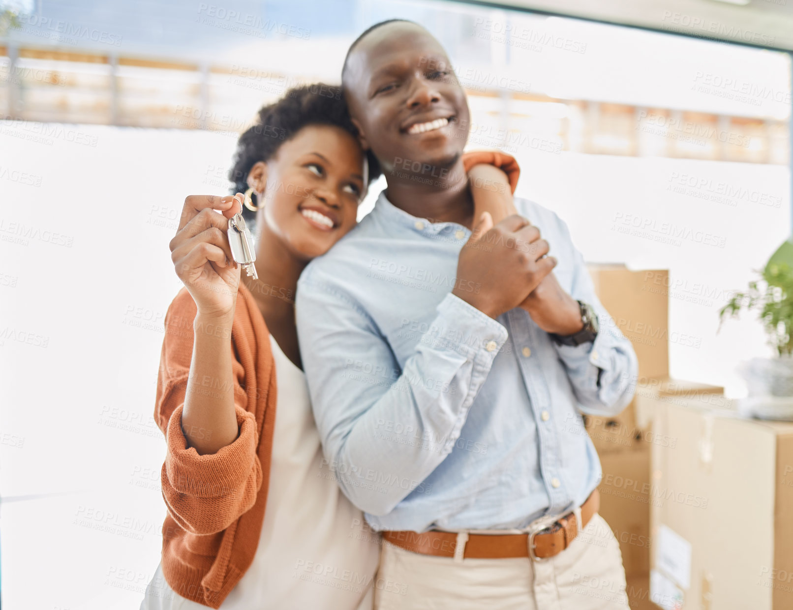 Buy stock photo Black couple, keys and boxes with new home, love and hug in living room of house for living together. Romance, smile and mortgage with man and woman in apartment for future investment opportunity