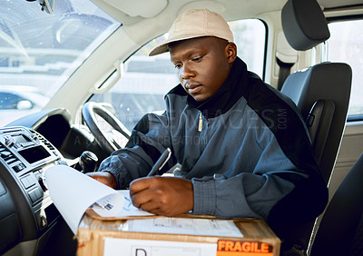 Buy stock photo Shot of young man delivering a package while sitting in a vehicle