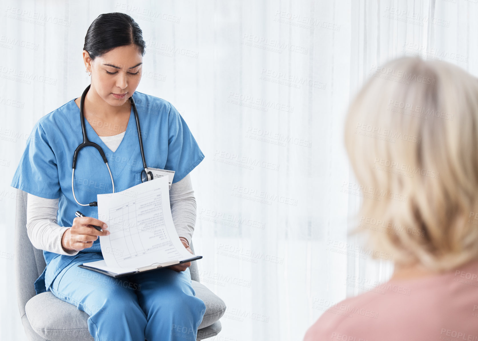 Buy stock photo Shot of a female nurse sitting with a clipboard while having a consultation with a patient