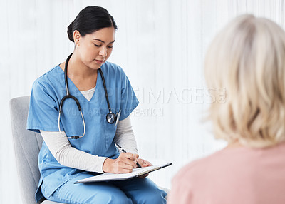 Buy stock photo Shot of a female nurse sitting with a clipboard while having a consultation with a patient