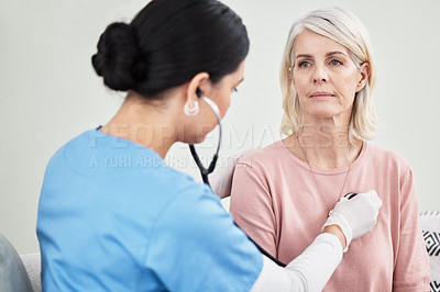 Buy stock photo Shot of a female doctor examining a patient with a stethoscope