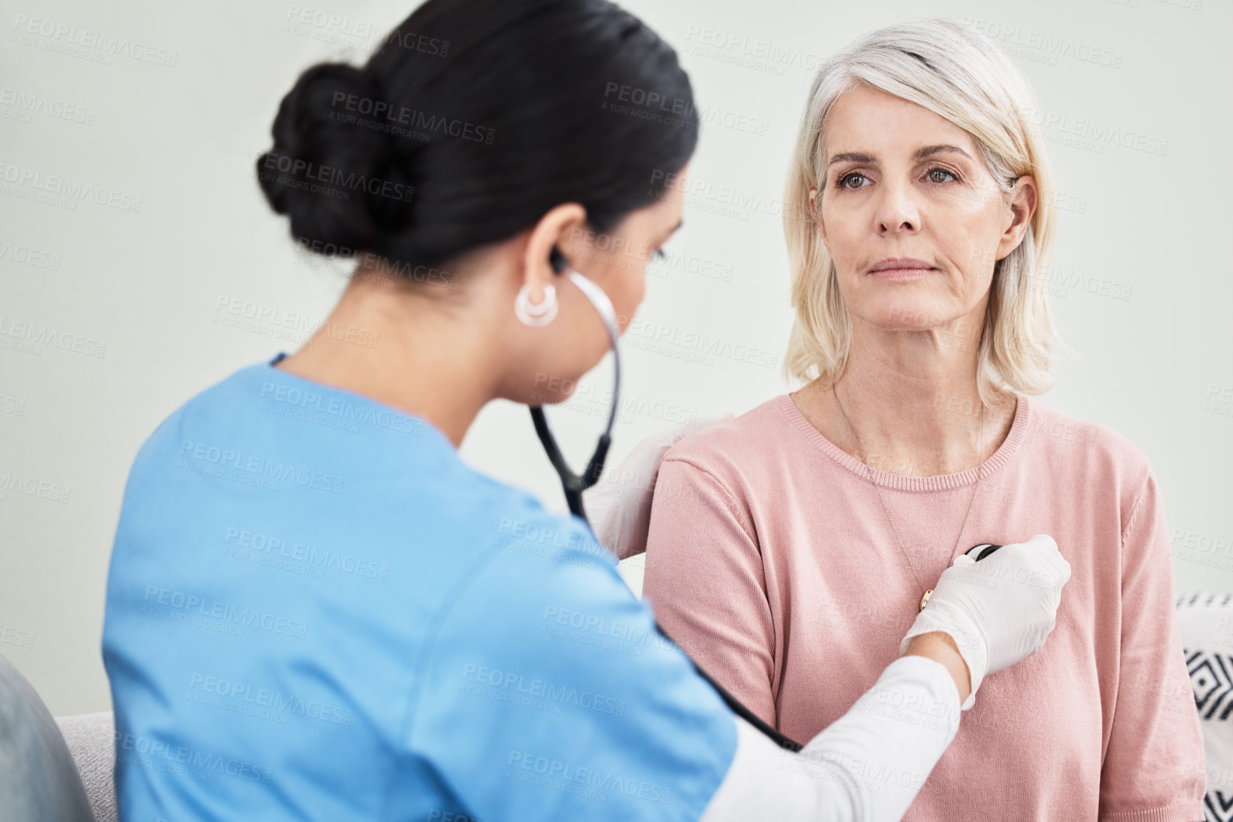 Buy stock photo Shot of a female doctor examining a patient with a stethoscope
