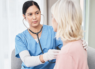 Buy stock photo Shot of a female doctor examining a patient with a stethoscope