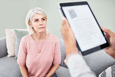 Buy stock photo Shot of a nurse using a digital tablet during a consultation with her patient