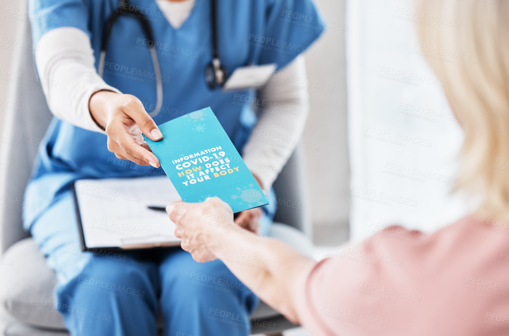 Buy stock photo Shot of a female nurse giving her patient a Covid-19 information pamphlet