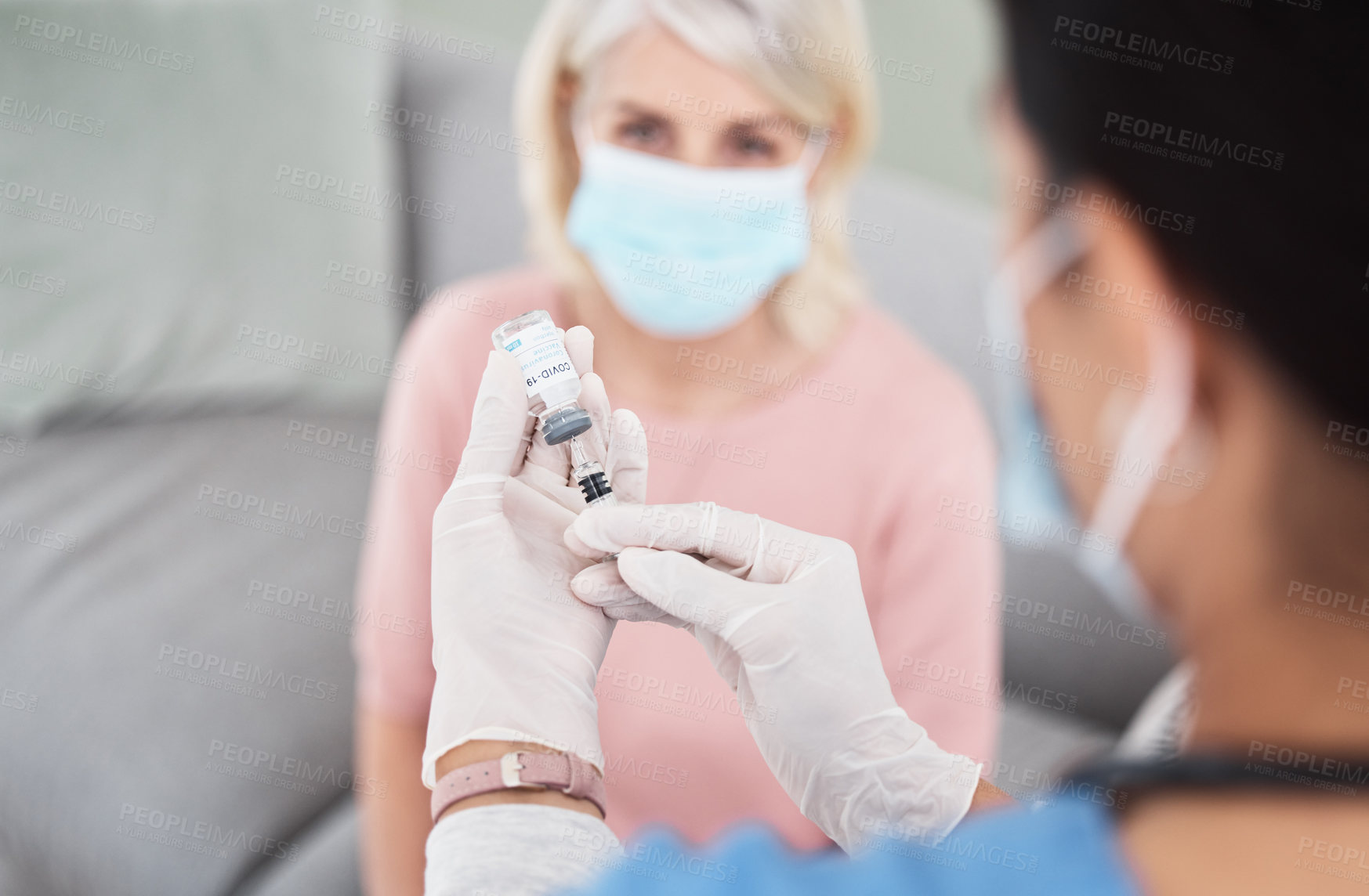 Buy stock photo Shot of a female nurse getting ready to vaccinate a patient