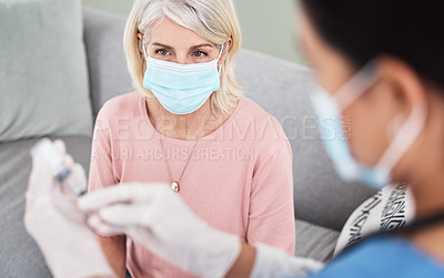 Buy stock photo Shot of a female nurse getting ready to vaccinate a patient