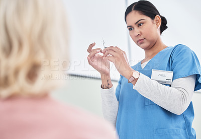 Buy stock photo Shot of a female nurse getting ready to inject her patient