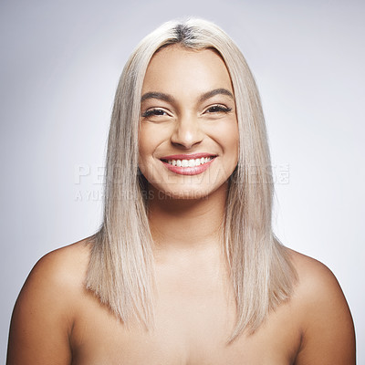 Buy stock photo Shot of an attractive young woman standing alone and posing against a grey background in the studio