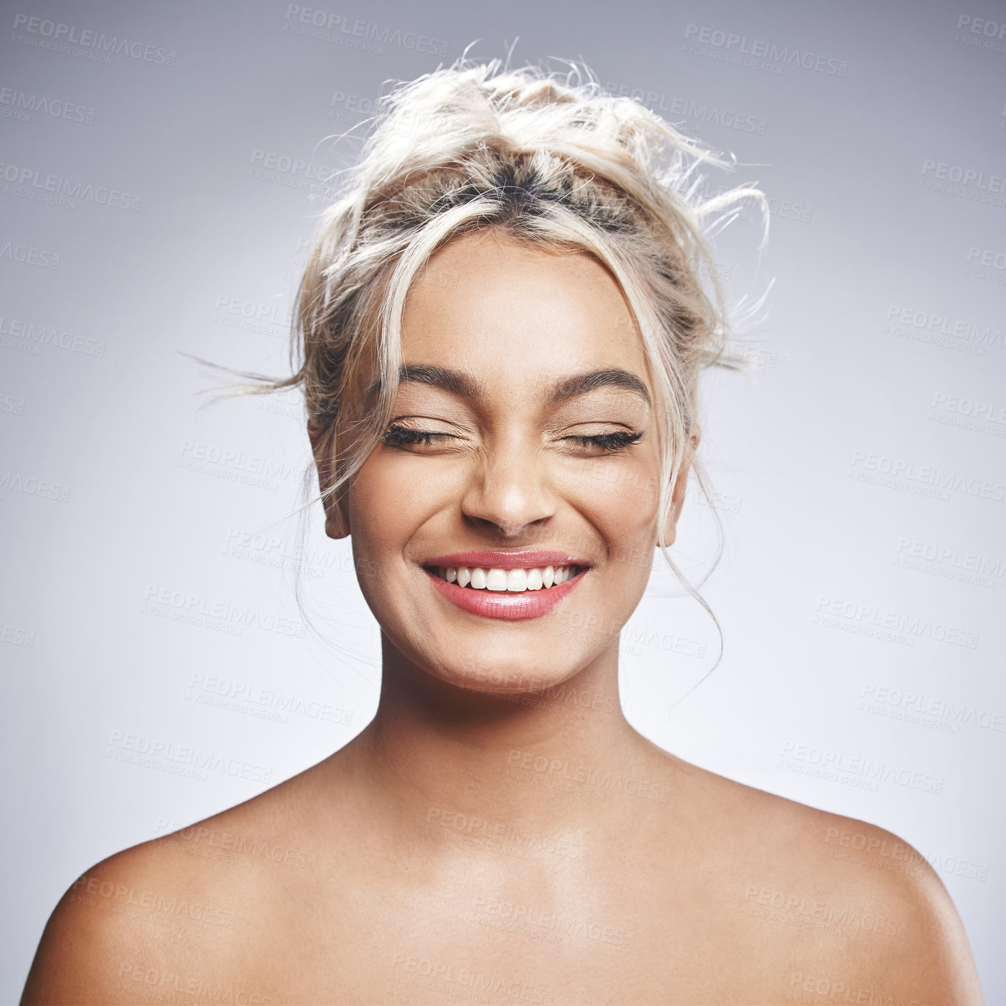 Buy stock photo Shot of an attractive young woman standing alone and posing against a grey background in the studio