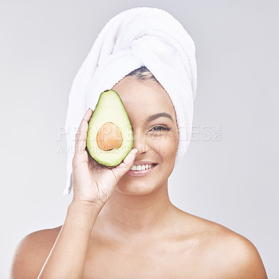 Buy stock photo Studio shot of a beautiful young woman holding an avocado in front of her eye against a grey background