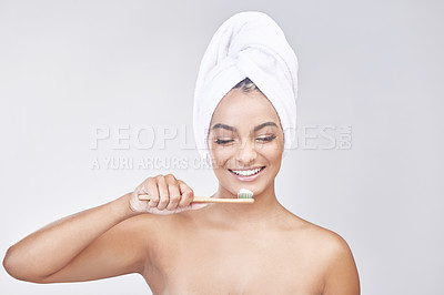 Buy stock photo Studio shot of a beautiful young woman brushing her teeth against a grey background