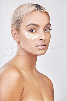 Buy stock photo Studio shot of a beautiful young woman wearing an under-eye beauty patch against a grey background