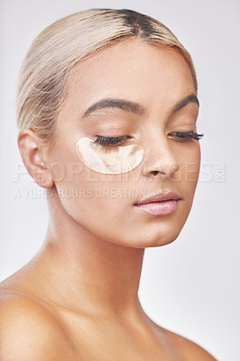 Buy stock photo Studio shot of a beautiful young woman wearing an under-eye beauty patch against a grey background