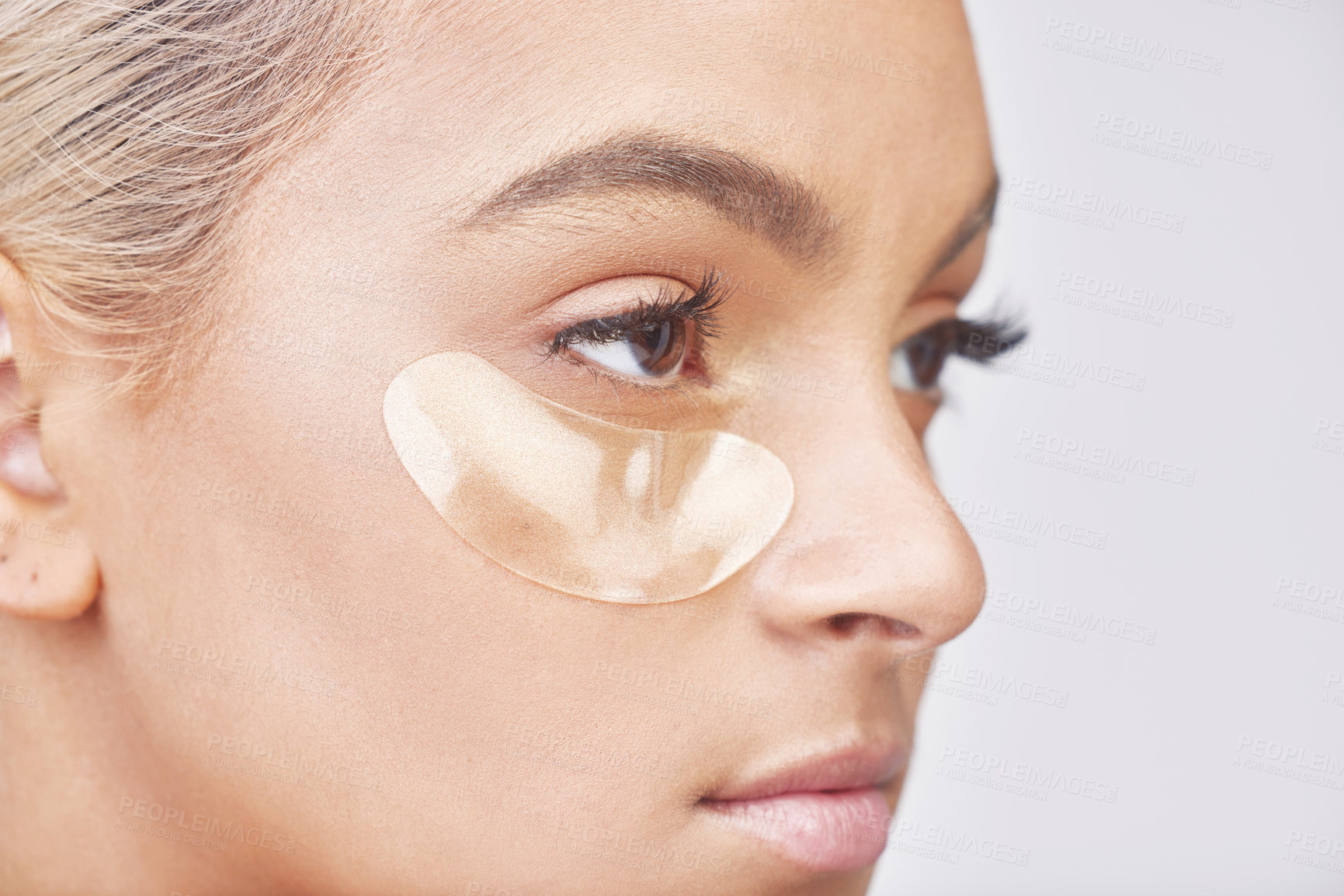 Buy stock photo Studio shot of a beautiful young woman wearing an under-eye beauty patch against a grey background