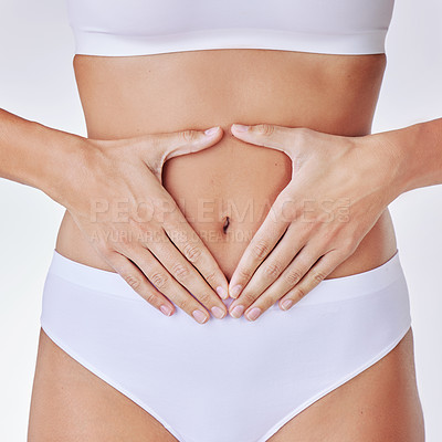 Buy stock photo Hands heart, stomach and woman in studio showing gut health, wellness and weight loss. Digestion, female person and hand by abdomen with sign for healthy body care and fitness with white background